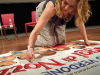 L'attrice Claudia Gerini autografa il poster di Viaggi di Nozze